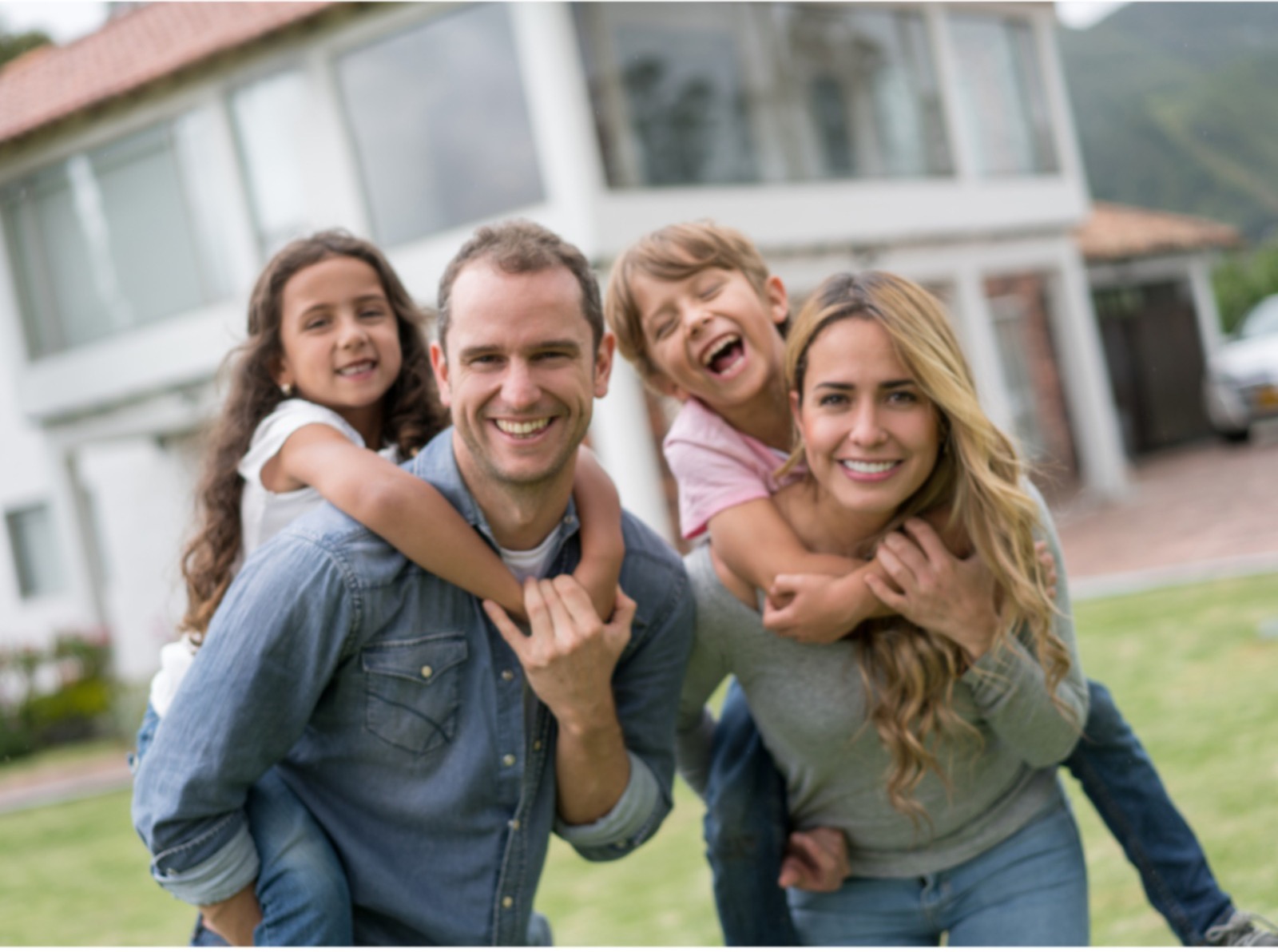 Família reunida em frente à casa que utiliza sistema de aproveitamento de água da chuva.